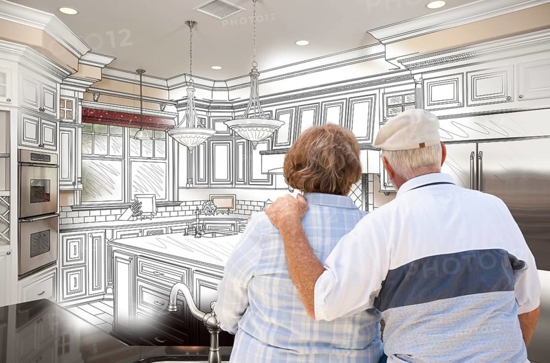 Senior couple looking over custom kitchen design drawing and photo combination