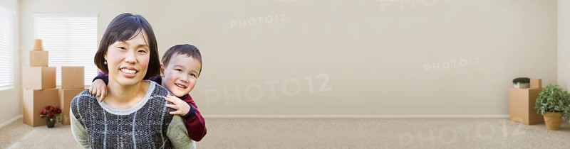 Banner of chinese mother and mixed-race child inside empty room with moving boxes and plants