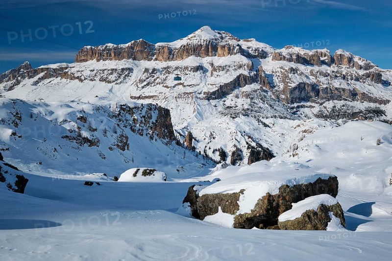 View of a ski resort piste with people skiing in Dolomites in Italy with cable car ski lift Ski area Arabba Arabba