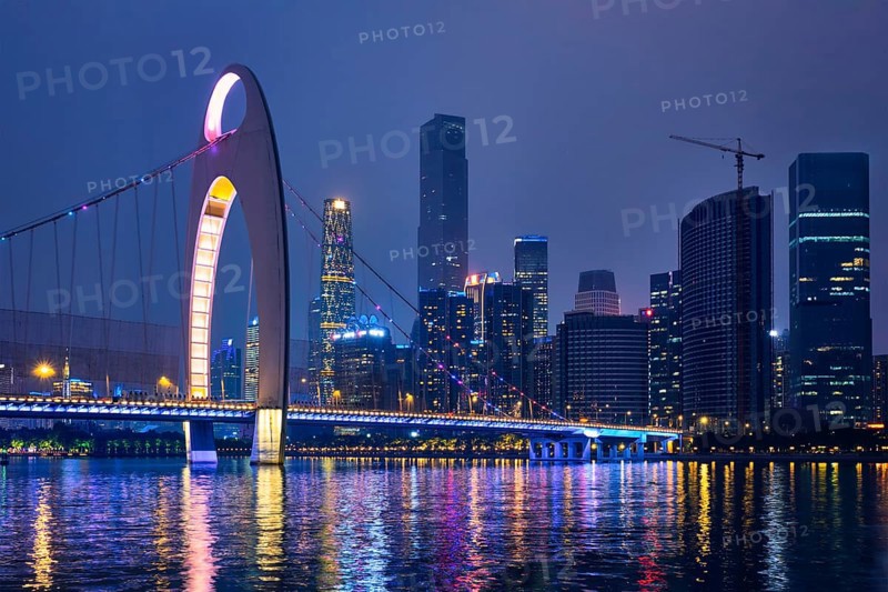 Guangzhou cityscape skyline over the Pearl River with Liede Bridge illuminated in the evening. Guangzhou