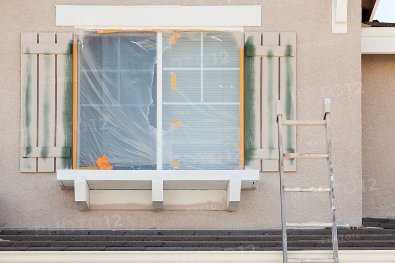 Construction ladder leaning up against A house being painted