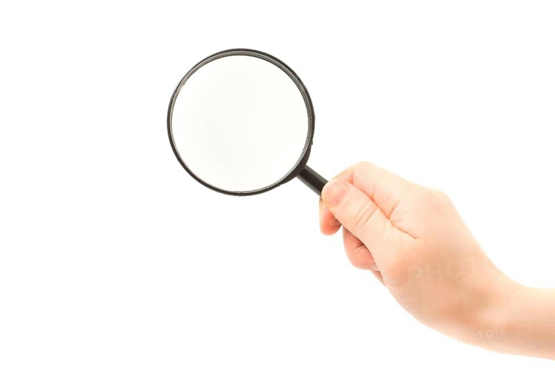 Woman hand holding magnifying glass isolated on white background