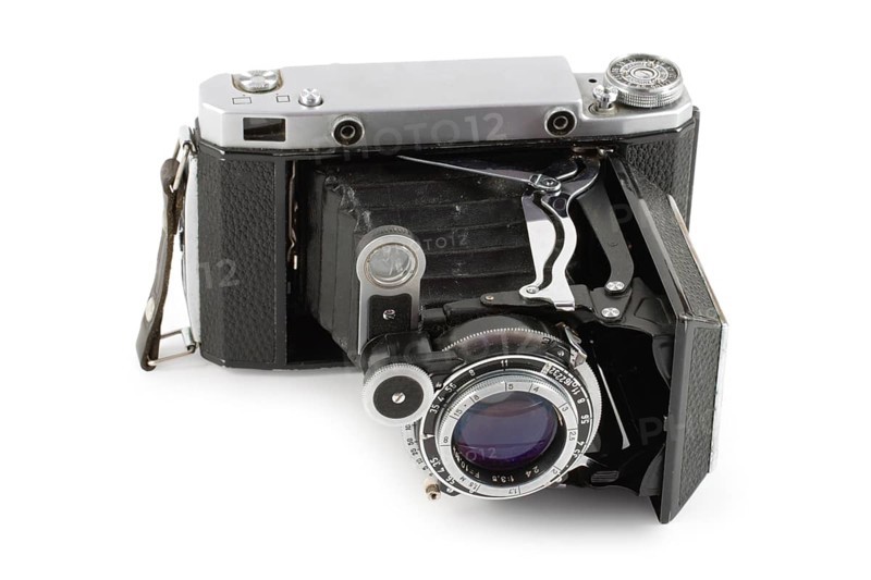 Old folding camera isolated on white background