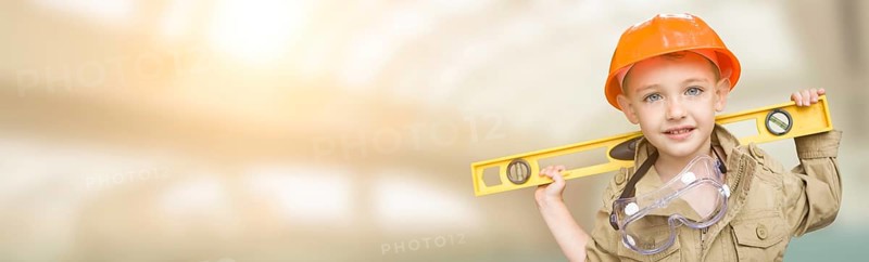 Cute young boy dressed as contractor holding level wide banner with room for text