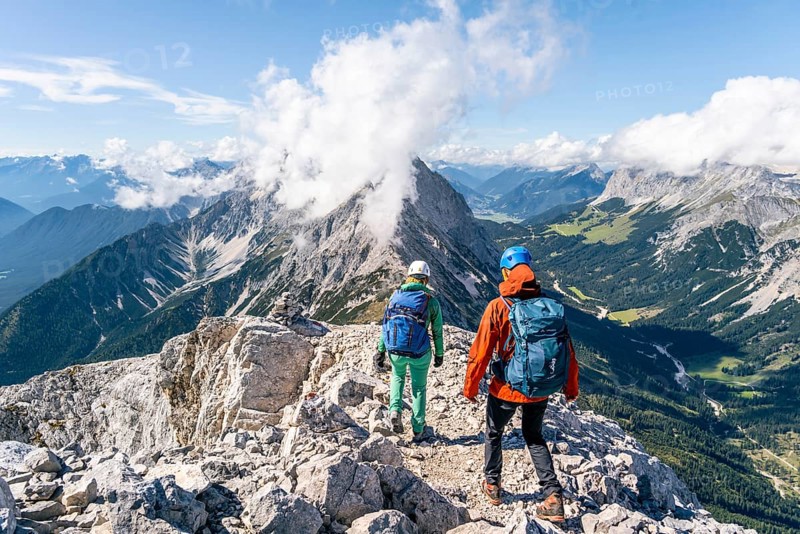 Hiker with climbing helmet on a steep rocky ridge