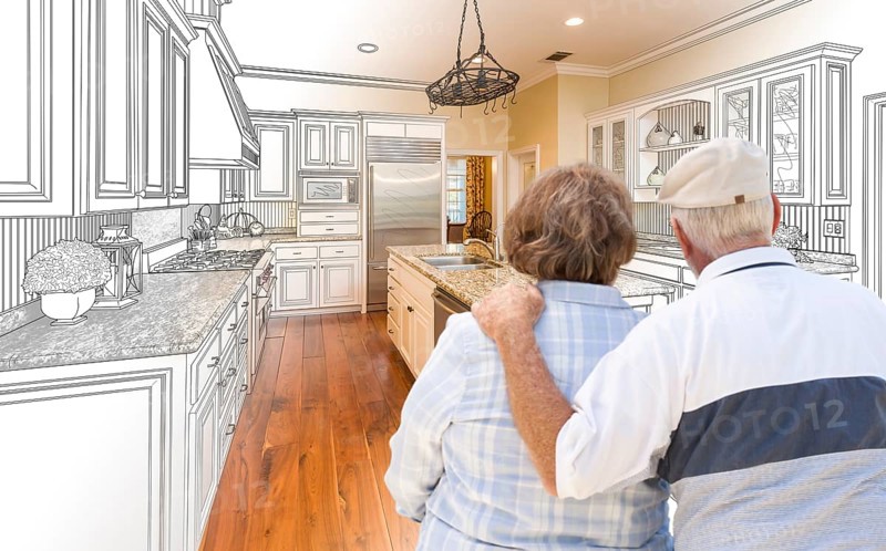 Senior couple looking over custom kitchen design drawing and photo combination