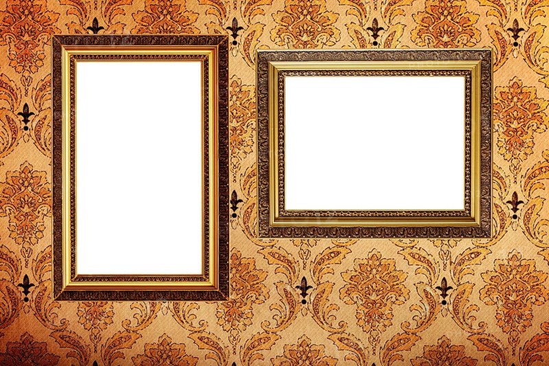 Vintage gold plated picture frames on retro wallpaper background