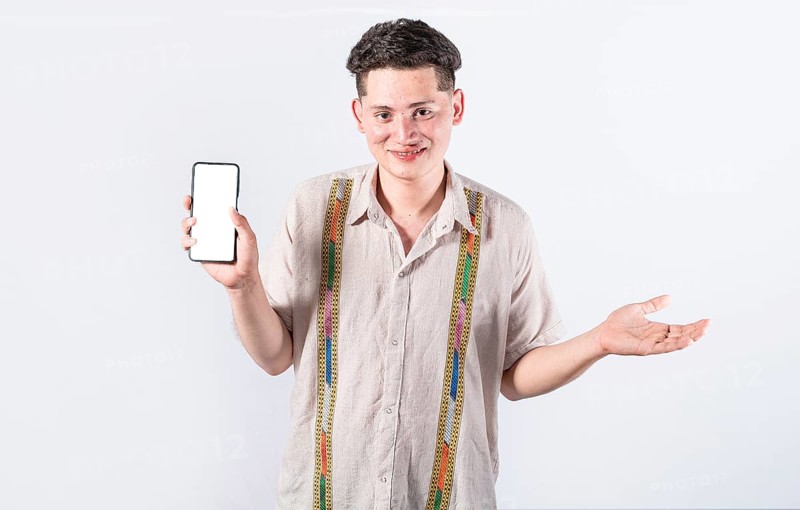 Handsome man smiling positive showing mobile phone blank screen with another hand palm open