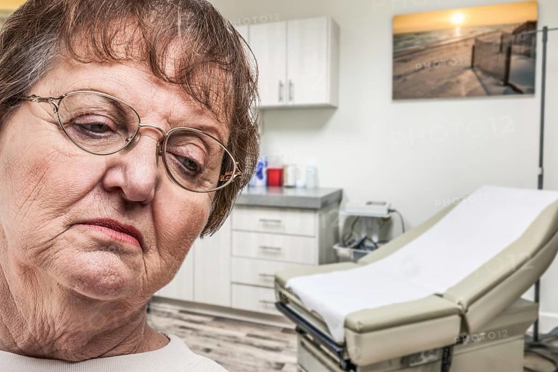 Worried senior adult woman waiting in doctor office