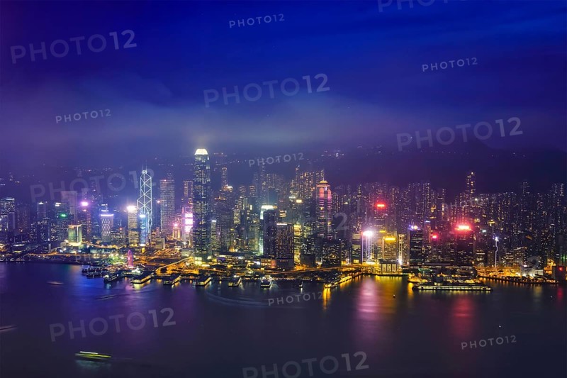 Aerial view of illuminated Hong Kong skyline cityscape downtown skyscrapers over Victoria Harbour in the evening. Hong Kong