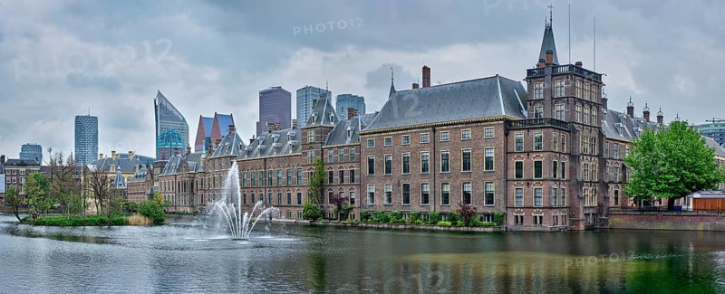 Panorama of the Binnenhof House of Parliament and the Hofvijver lake with downtown skyscrapers in background