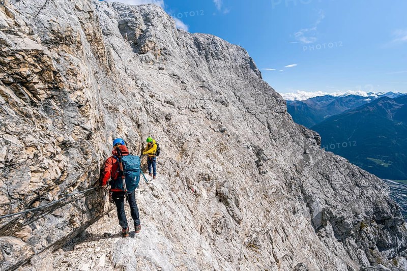 Two climbers on a via ferrata on a steep rock face