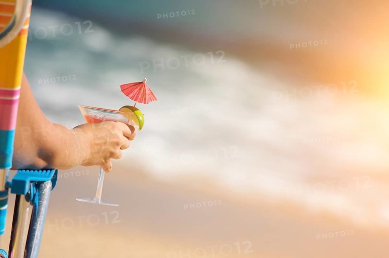 Woman relaxing on beach with tropical drink