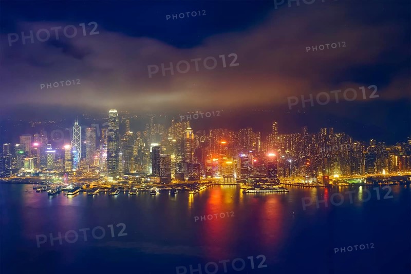 Aerial view of illuminated Hong Kong skyline cityscape downtown skyscrapers over Victoria Harbour in the evening. Hong Kong