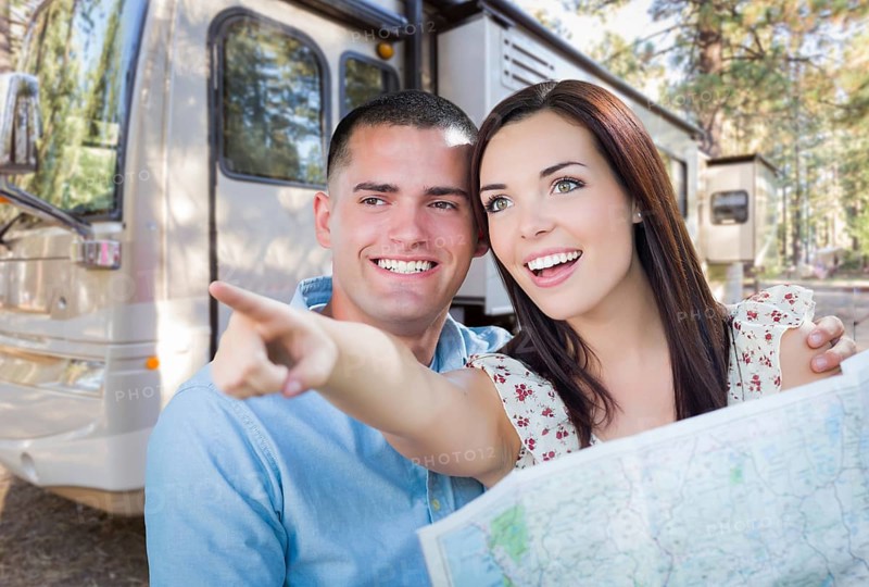 Young military couple looking at map in front of RV