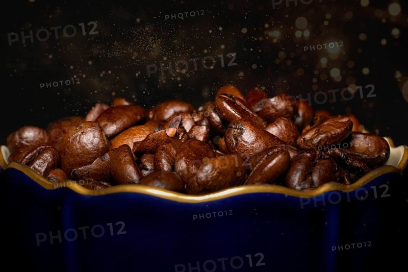 Roasted coffee of the Arabica variety in a porcelain cup in cobalt blue with gold rim
