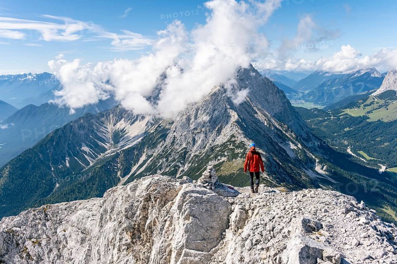 Hiker with climbing helmet on a steep rocky ridge