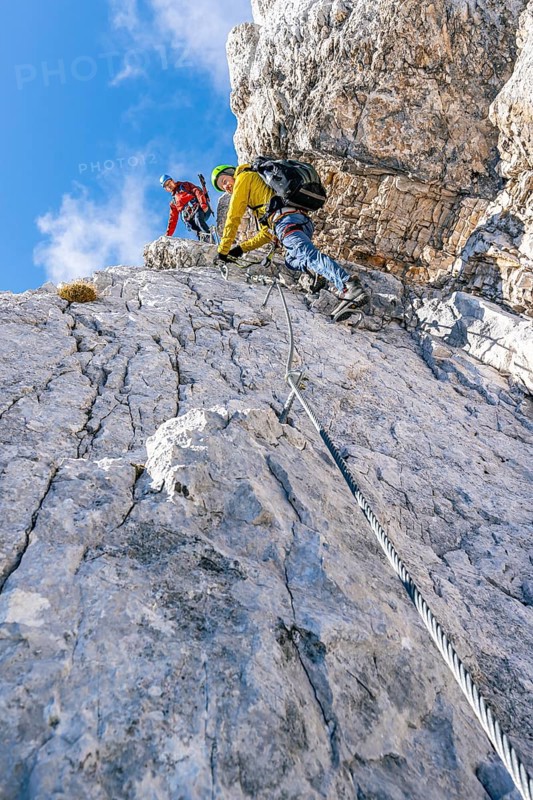 Two climbers on a via ferrata on a steep rock face