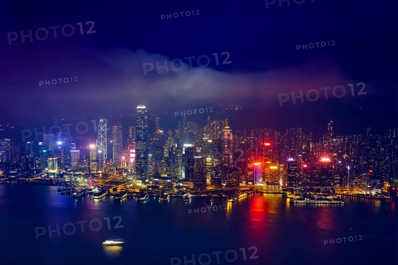Aerial view of illuminated Hong Kong skyline cityscape downtown skyscrapers over Victoria Harbour in the evening. Hong Kong