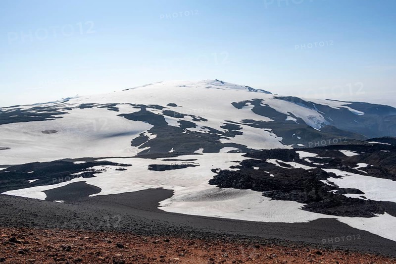Barren hilly volcanic landscape of snow and lava fields