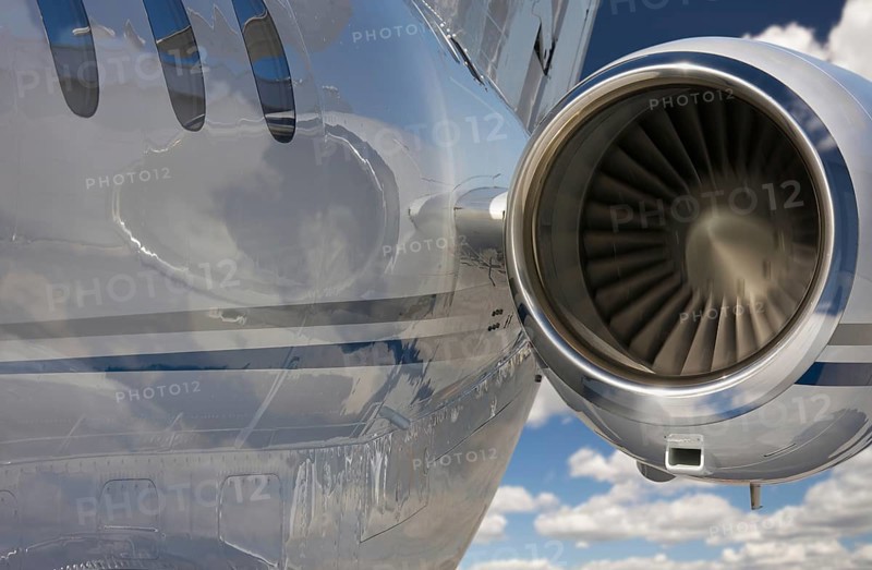 Private jet and engine abstract over clouds and sky