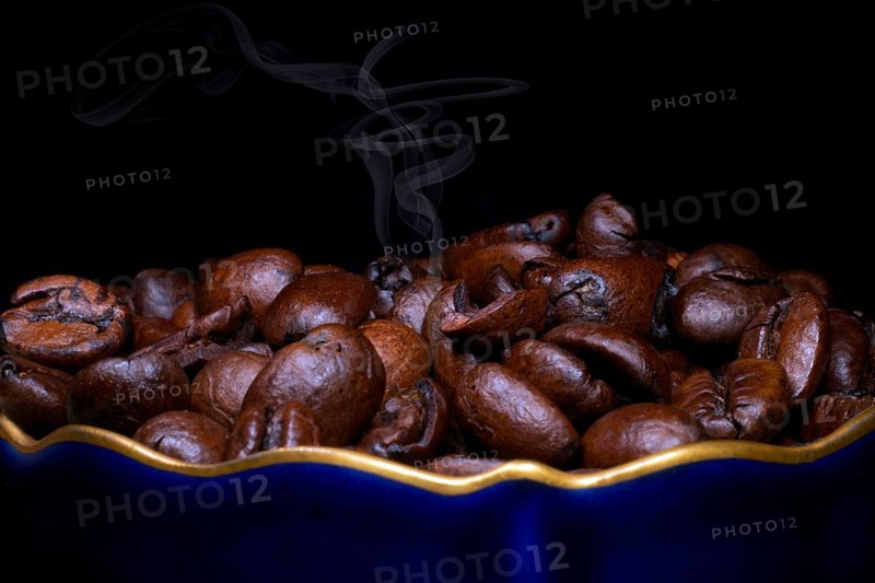Roasted coffee of the Arabica variety in a porcelain cup in cobalt blue with gold rim