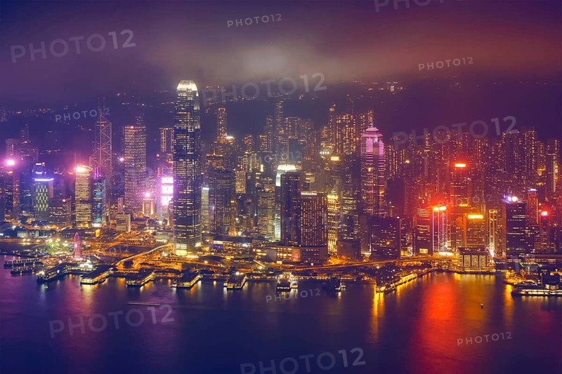 Aerial view of illuminated Hong Kong skyline cityscape downtown skyscrapers over Victoria Harbour in the evening. Hong Kong
