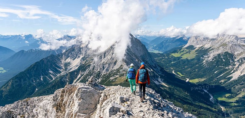 Hiker with climbing helmet on a steep rocky ridge