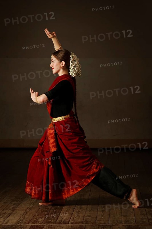 Young woman in sary dancing classical traditional indian dance Bharat Natyam