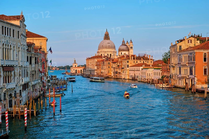 Panorama of Venice Grand Canal with gondola boats and Santa Maria della Salute church on sunset from Ponte dell'Accademia bridge. Venice