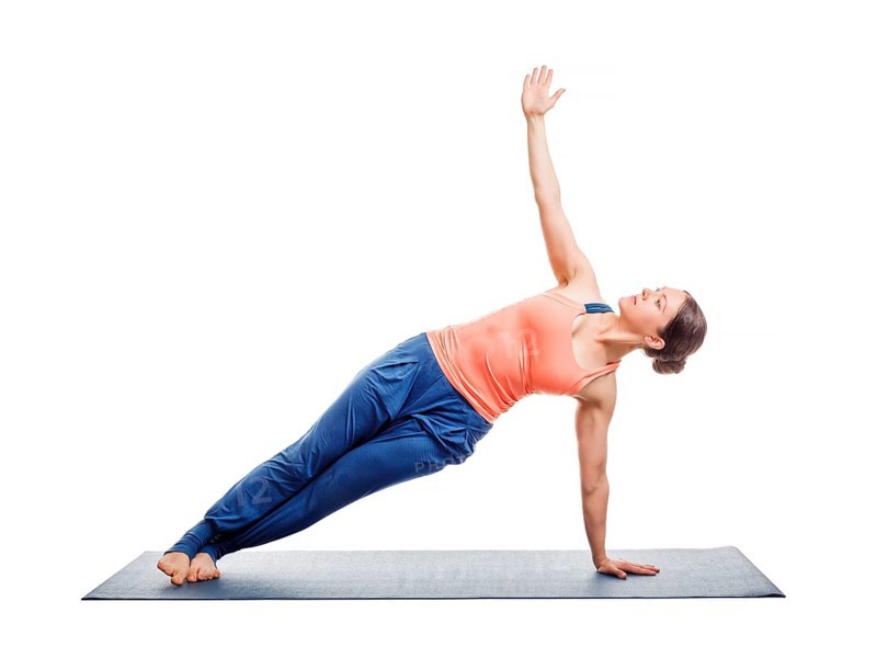 Beautiful sporty fit woman practices yoga asana Vasisthasana