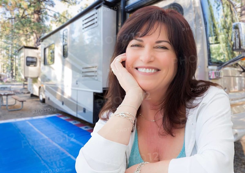 Attractive middle aged woman outdoor portrait in front of class A RV
