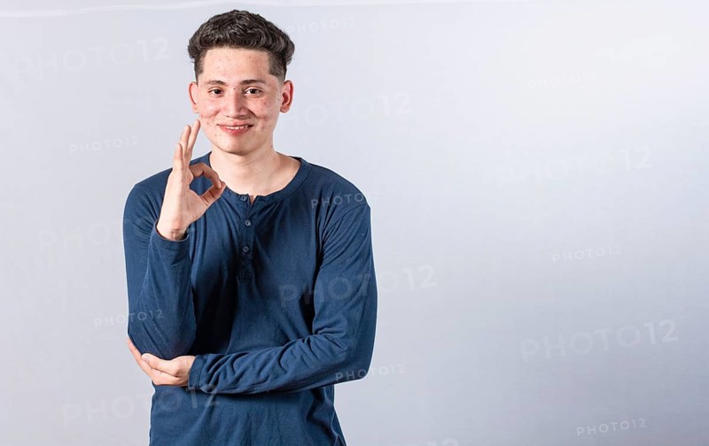 Smiling man showing ok gesture looking at camera