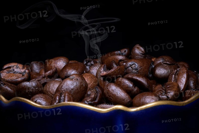 Roasted coffee of the Arabica variety in a porcelain cup in cobalt blue with gold rim