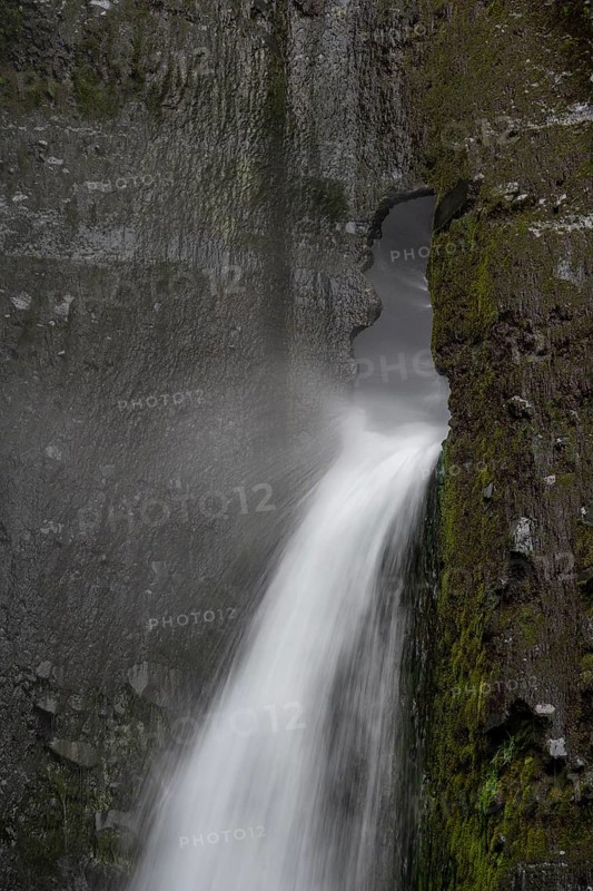 Waterfall flowing through small rock hole