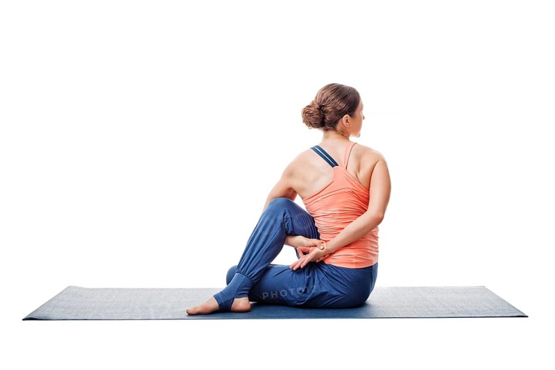 Beautiful sporty fit woman practices yoga asana Ardha matsyendrasana
