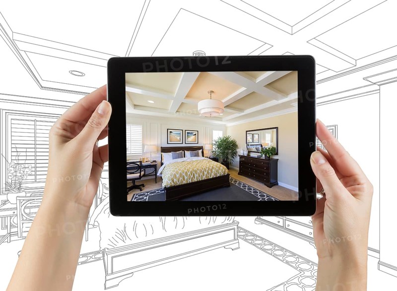 Female hands holding computer tablet with bedroom photo on screen