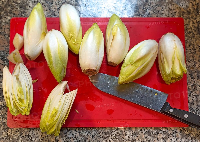 Fresh chicory with knife on a cutting board