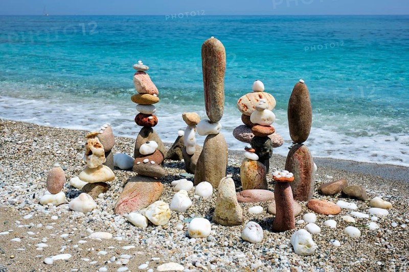 Concept of zen balance relaxation peace and harmony Pebbles stacks on the beach coast of the blue sea in the nature Meditative art of stone stacking