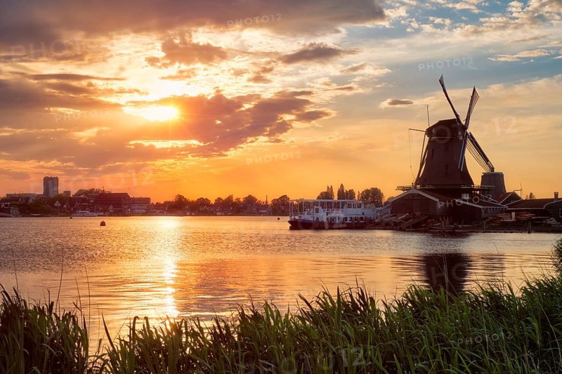 Windmills at famous tourist site Zaanse Schans in Holland on sunset with dramatic sky Zaandam