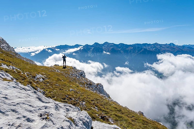 Hiker with climbing helmet on a steep rocky ridge