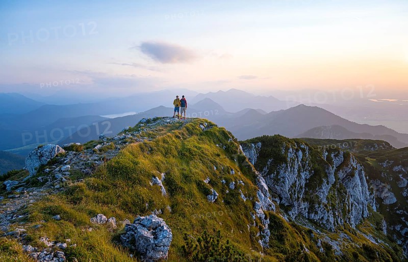 Two hikers at the summit of the Benediktenwand at sunset
