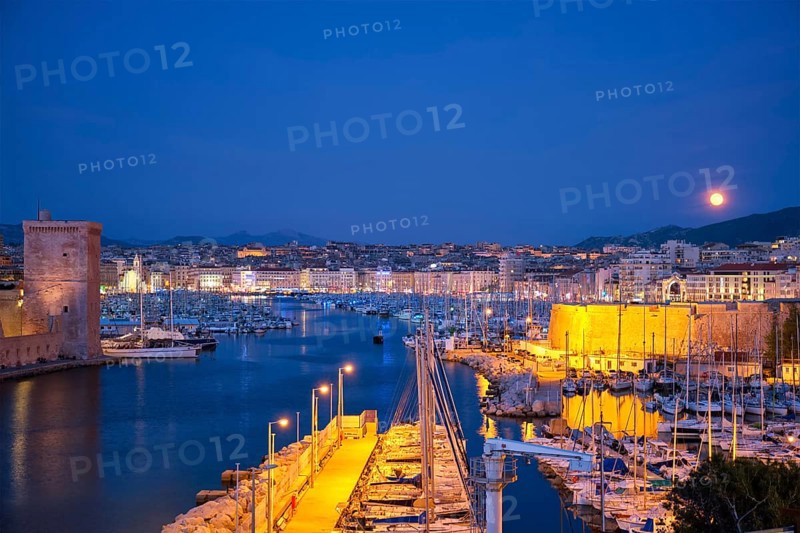 Marseille Old Port and Fort Saint-Jean illumintaed in night with moon