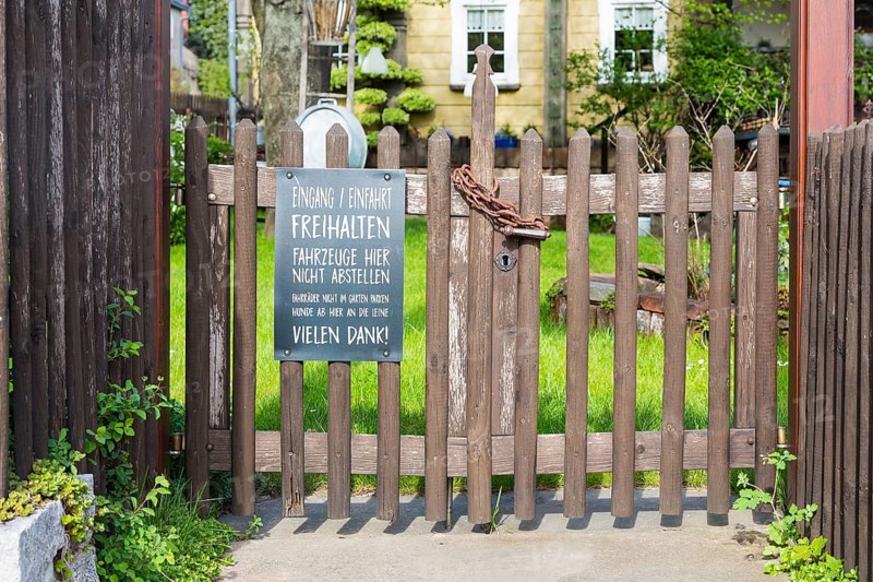 Locked garden gate of a restaurant with notice