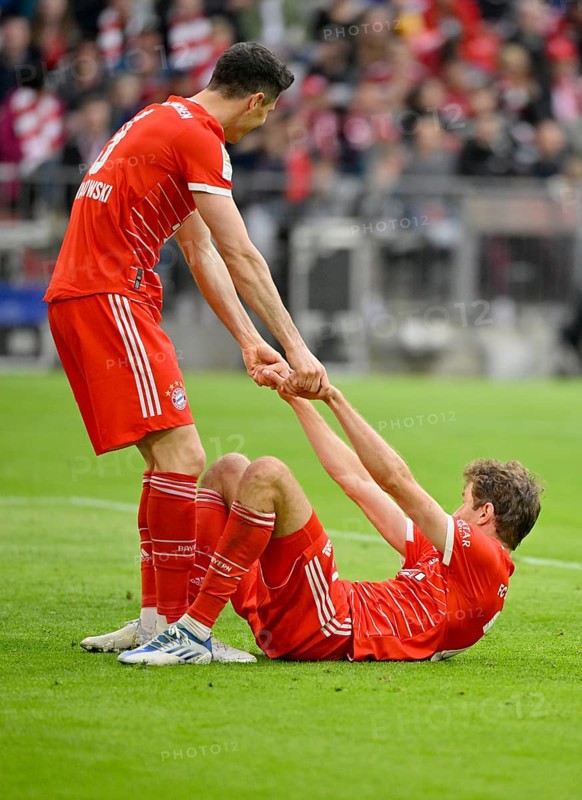 Robert Lewandowski FC Bayern Munich FCB helps Thomas Mueller FC Bayern Munich FCB to his feet
