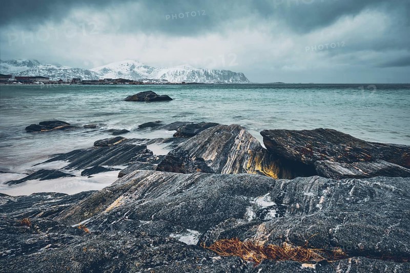 Waves of Norwegian sea on rocky beach of fjord. Ramberg beach