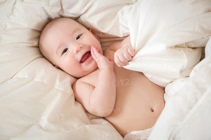 Young mixed-race chinese and caucasian baby boy having fun on his blanket