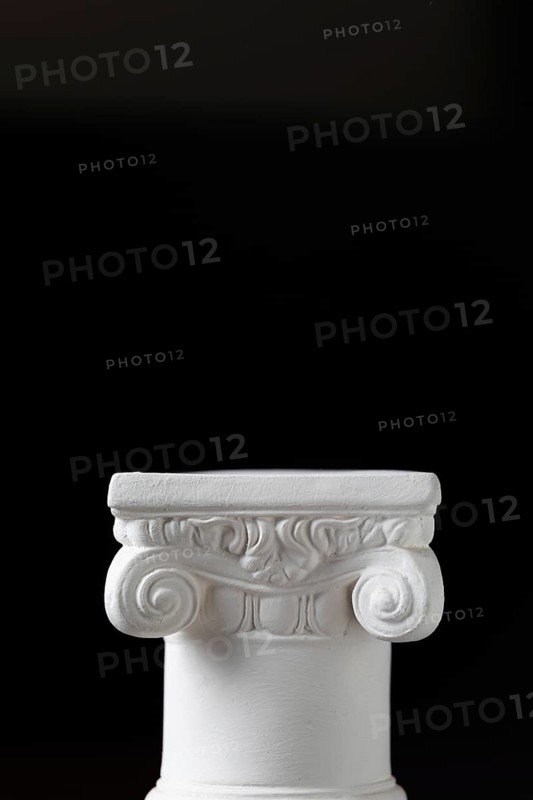 White ionic design column on dark background