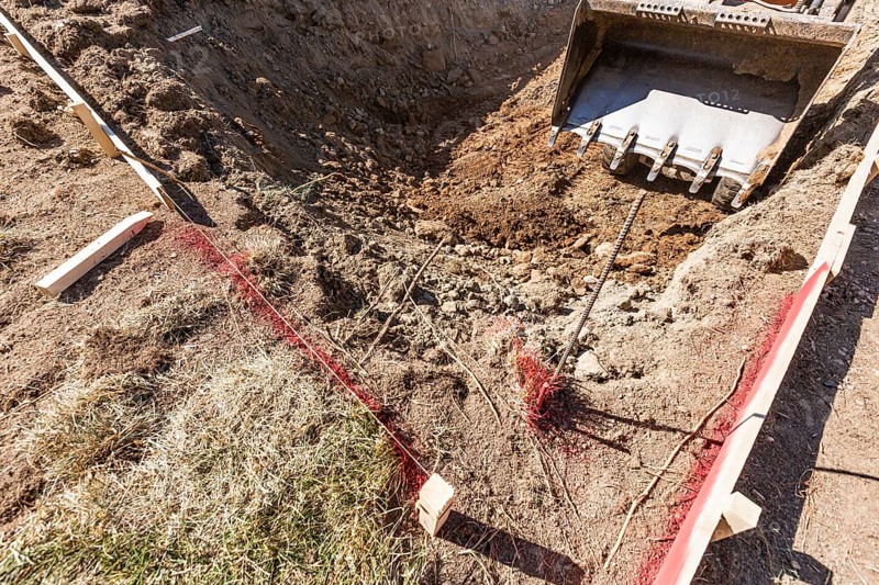 Small bulldozer digging in yard for pool installation