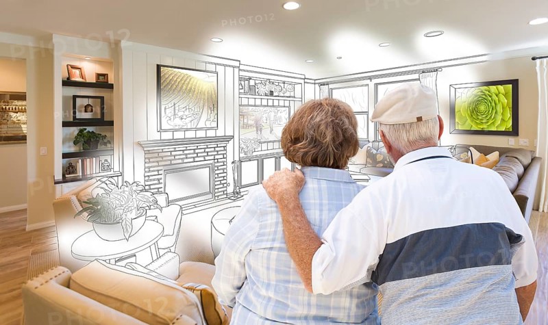 Curious senior couple looking over custom living room design drawing photo combination
